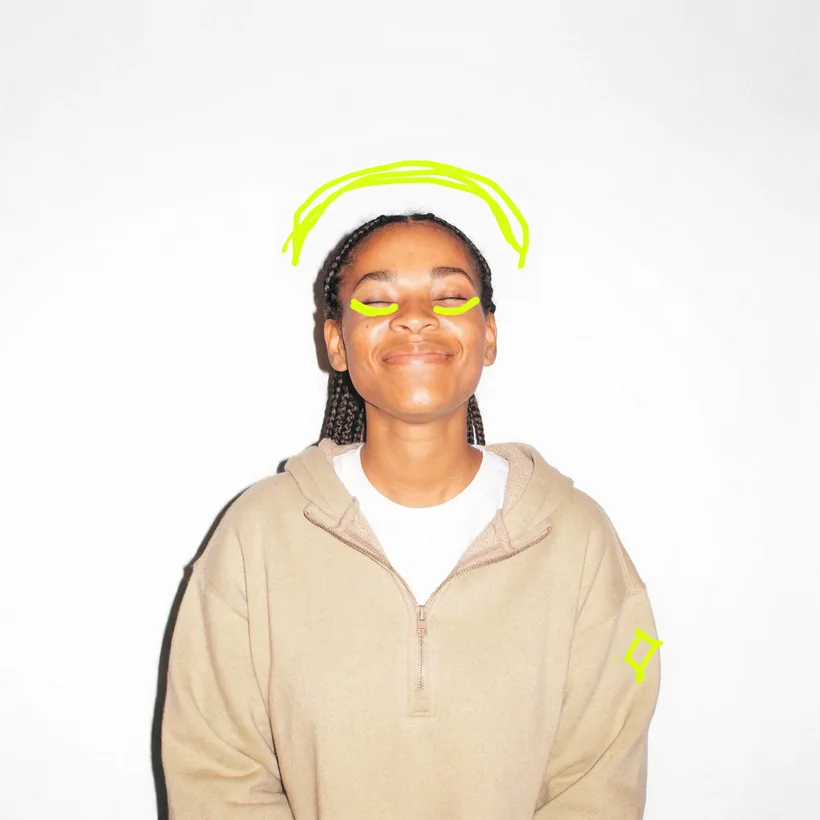 Laura smiling with her eyes closed in a studio portrait, a lime halo doodled above her