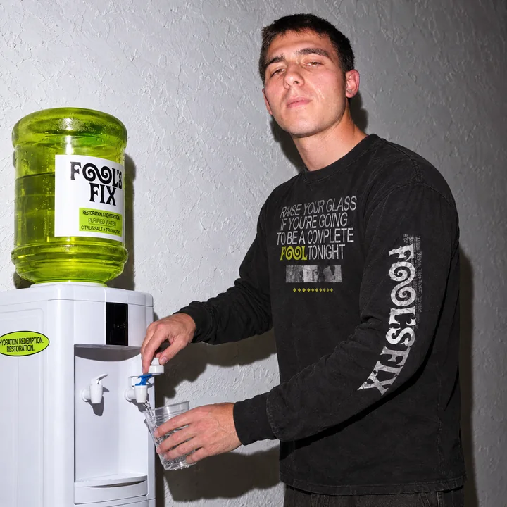 A man filling a cup at the Fool's Fix water cooler